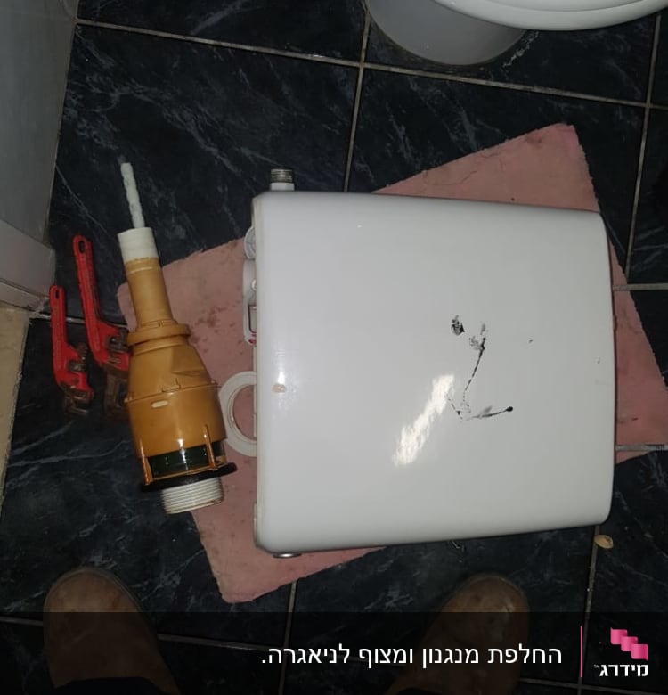 מיכל הדחה, כלי עבודה וצנרת על רצפה